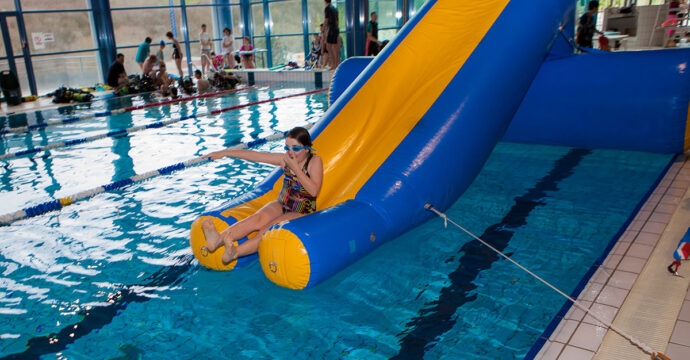 Une enfant s'amuse sur le toboggan de la structure gonflable au centre aqua.